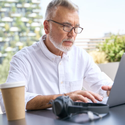 Older Senior Business Man Using Laptop